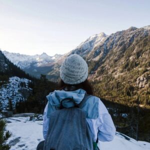 A person standing on top of a snow covered slope.